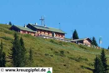 Brauneckhütte und Brauneck-Gipfelkreuz dahinter